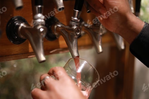 Preview: Hand Of Bartender Pouring A Large Lager Of Red Beer In Tap.