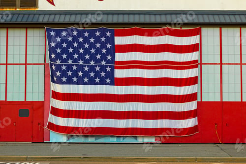 Preview: Oversized American Flag On The Facade Of A Red And White Building