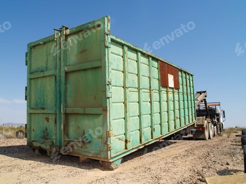 Preview: A Large Green Metal Garbage Dumpster Being Delivered To A Construction Site In Arizona.