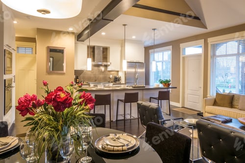 Preview: Modern Round Dining Room Table Set For Dinner In A Luxury House, With A Kitchen In The Background