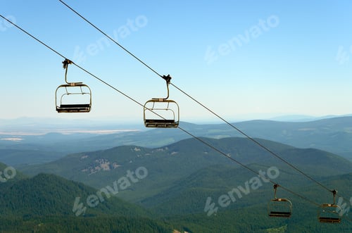 Preview: Chairlift On Mount Hood With Green Pine Tree Covered Hills In The Background