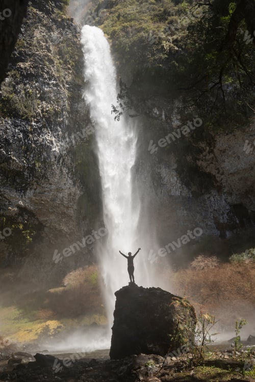 Preview: Woman On Top Of The Stone Looking At The Majestic And Imposing Waterfall.