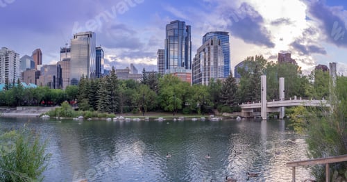 Preview: Foot Bridge Reflected In The Bow River At Princes Island Park And The Urban Skyline In Calgary