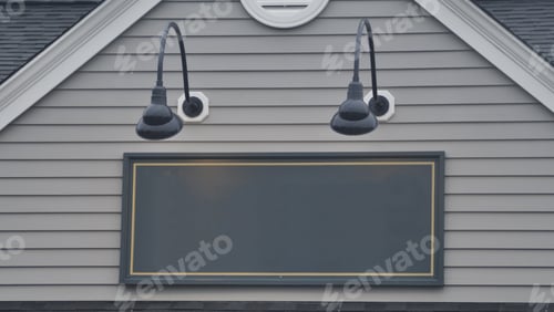 Visualização: Edifício de escritórios com placa verde em branco iluminada por algumas lâmpadas