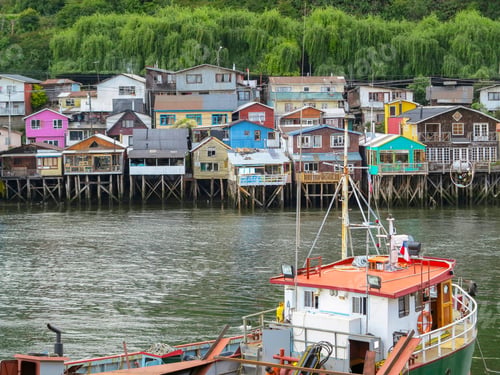 Preview: Houses Built On Stilts, Known Locally As Palafitos, Lining The Waters Edge In Castro, Capital Of