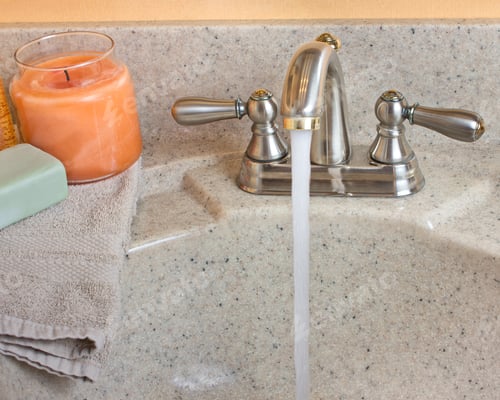 Preview: Typical Bathroom Sink With Running Water And Soap, Candle And Cloth On The Counter