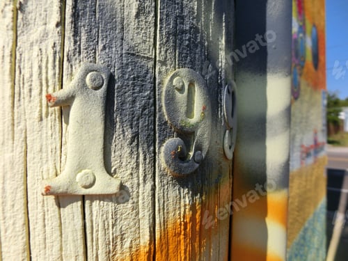 Preview: Metal Numbers Nailed To Telephone Pole With Vibrant Spray Paint Color
