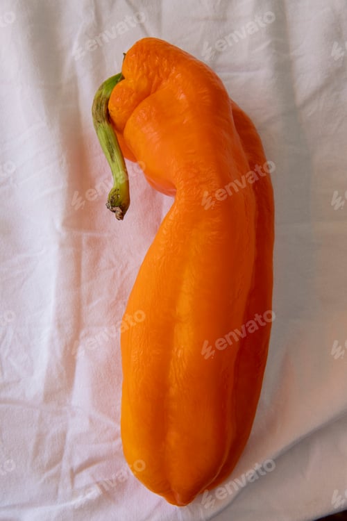 Preview: Orange Pepper On Table With White Wrinkled Tablecloth