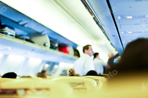 Preview: Blurred Photo Of Airplane Interior, Stewards And Passengers With Bags On Shelves. Concept Of Cheap