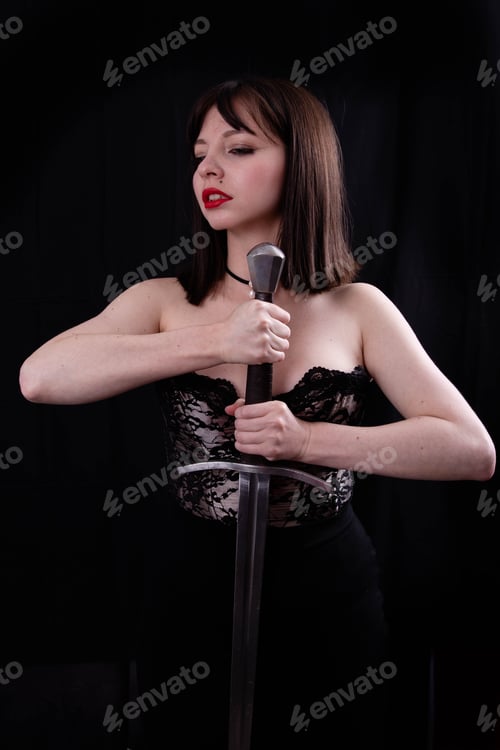 Preview: Attractive Girl Poses With Leather Corset And Medieval Sword In The Studio
