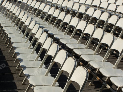 Preview: Rows of White Folding Chairs on Asphalt
