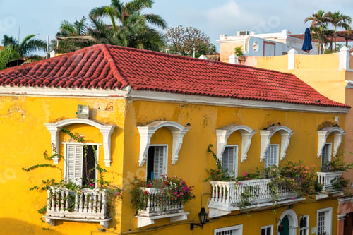 Preview: Historic Yellow Colonial Building With Bougainvillea Flowers On The Balconies In Cartagena, Colombia