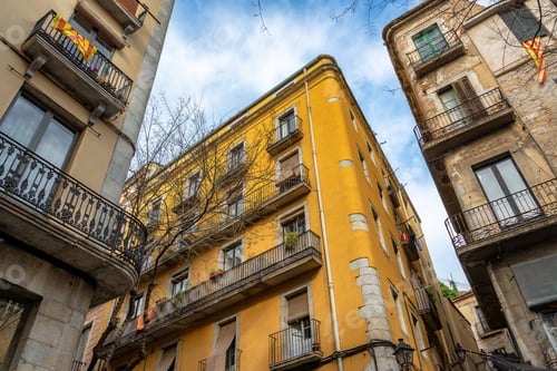 Preview: Looking Up At A Yellow Building On A Street Corner In Historic Girona, Spain