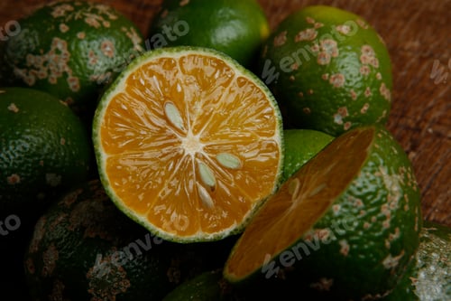 Preview: Group Of Juicy Ripe Rangpur Limes Spread On A Wooden Table. Rangpur Lime Or Mandarin Lime Is A