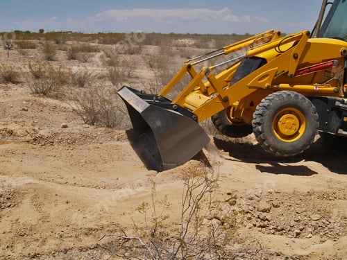 Preview: A Backhoe Machine Scraping Smooth The Dry Dirt Of A Construction Site In The Arizona Desert.