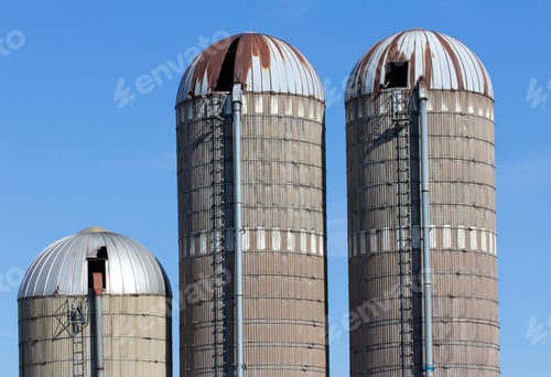 Preview: Three Weathered Silos Against Blue Sky In Rural United States.