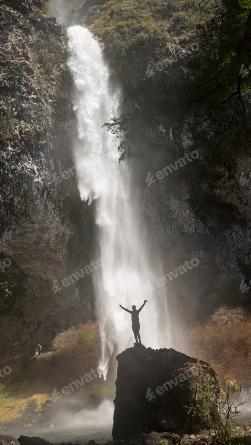 Preview: Woman On Top Of The Stone Looking At The Majestic And Imposing Waterfall.