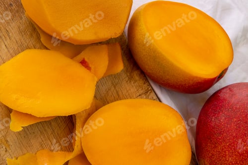 Preview: Sliced Mango On Cutting Board And White Wrinkled Tablecloth