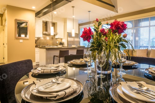Preview: Modern Round Dining Room Table Set For Dinner In A Luxury House, With A Kitchen In The Background
