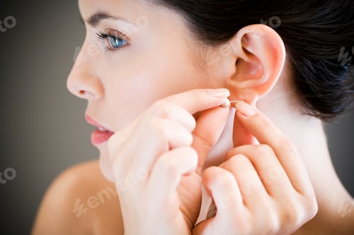 Preview: Woman Putting In Earrings On Her Ears