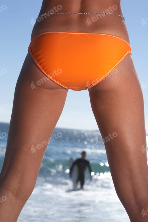 Preview: Vertical Shot Of The Backside Of The Lower Body Of A Female In Swimwear With A Male In The