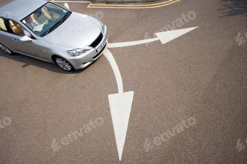Preview: Elevated View Of A Businessman Sitting In Car Beside Two Opposing Arrow Signs On Road Looking At