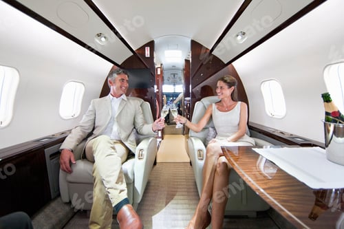 Preview: Close Up Of A Smiling Couple Making A Toast With Champagne Glasses In A Private Jet