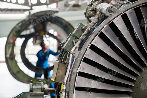 Preview: Close-Up Shot Of The Turbine Engine Of A Passenger Jet With An Engineer Working In The Background.