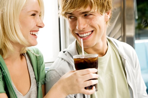 Preview: Young Couple Sharing A Cola Drink In A Diner