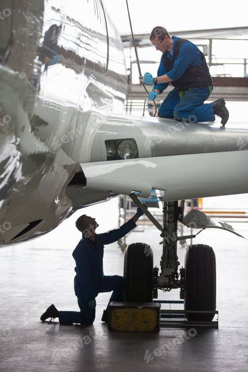 Preview: Vertical Shot Of Engineers Repairing The Landing Gear Of A Passenger Jet At A Hangar.