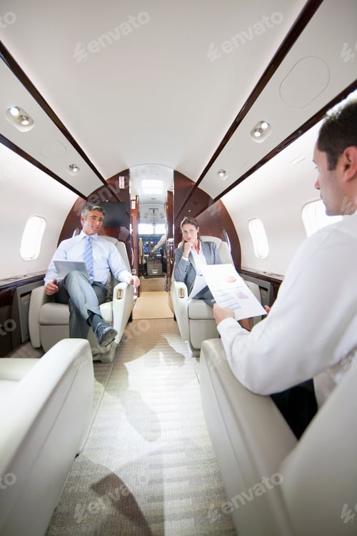 Preview: Vertical Shot Of Business Employees Talking While Sitting In A Private Jet