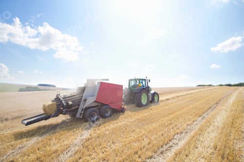Preview: Wide Shot Of A Tractor Carrying Straw Bales In A Rural Field On A Sunny Day.