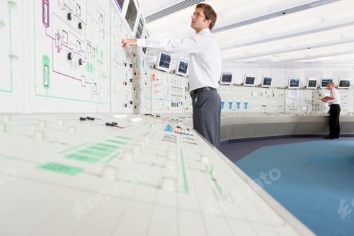 Preview: Low-Angle Shot Of A Young Engineer Adjusting Controls While Looking At A Computer Screen In The