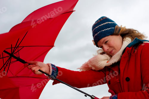 Preview: A Woman Struggling To Put Up An Umbrella In The Wind