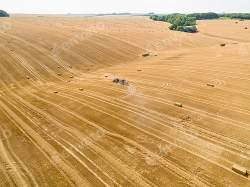 Preview: Aerial Of Tractor Baler Making Straw Bales In Field After Wheat Harvest In Summer On Farm