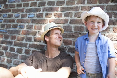 Preview: Father And Son Leaning Against Wall And Chewing Grass
