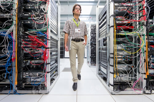 Preview: Full Shot Of A Technician With A Laptop Walking Through A Server Room At A Data Center.