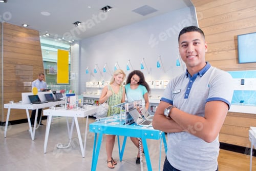 Preview: Store Assistants Are Standing In A Computer Store While Customers Are Browsing Through The Products