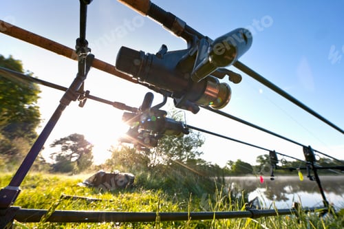 Preview: Close Wide Shot Of Carp Fishing Rods Against Sunny Blue Sky At Lakeside