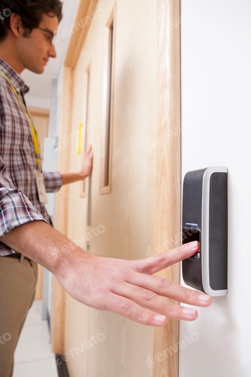 Preview: Vertical Shot Of A Man Using A Finger Print Reader To Open A Door.