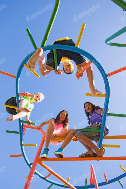 Preview: Low Angle Shot Of Smiling Children Sitting On Monkey Bars At A Playground