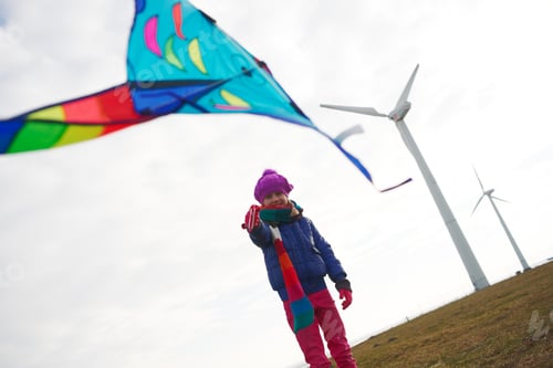Preview: Young Girl Flying Kite On Winter Day Near Wind Turbines