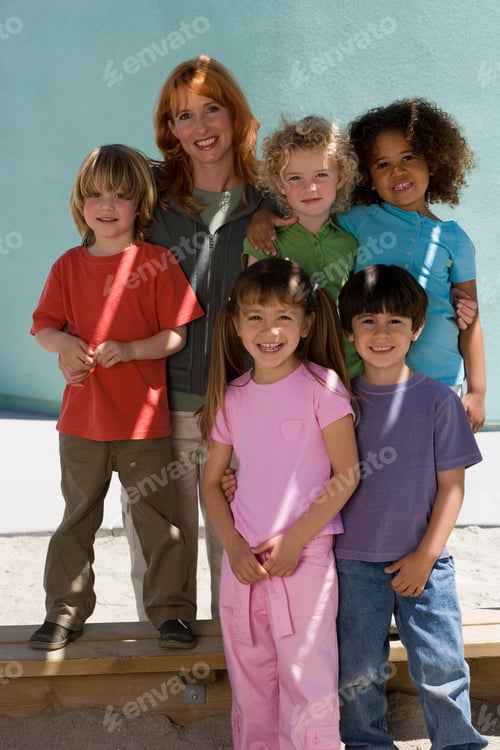 Preview: Portrait Of Female Elementary School Teacher With Pupils Outdoors In Playground