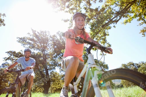 Preview: Close Up Of A Happy Couple Riding Mountain Bikes In A Rural Field