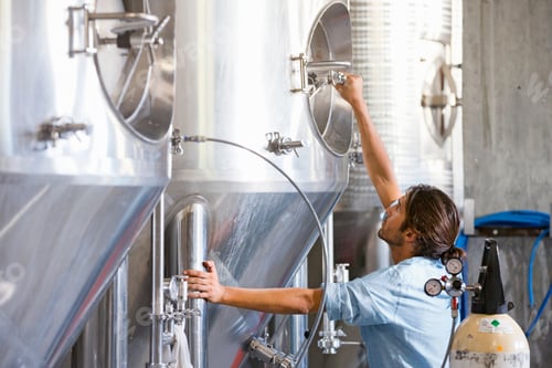 Preview: Wide Shot Of A Brewery Worker Checking Fermentation Process In Steel Vat