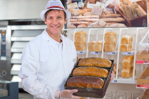 Preview: Baker With Loaves In Bread Department Of Supermarket