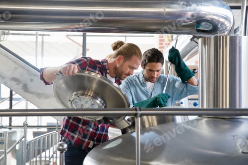 Preview: Wide Shot Of Brewery Workers Checking Fermentation Process In Steel Vat