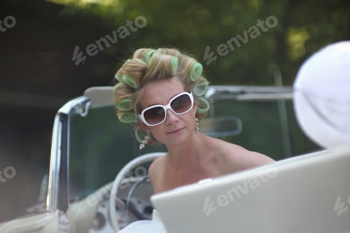 Preview: Bride In Open Top Car Wearing Hair Curlers On Wedding Day