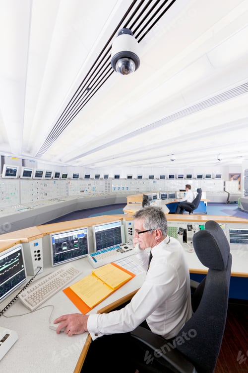 Preview: Vertical Shot Of A Senior Engineer Speaking On The Telephone While Operating A Computer At The