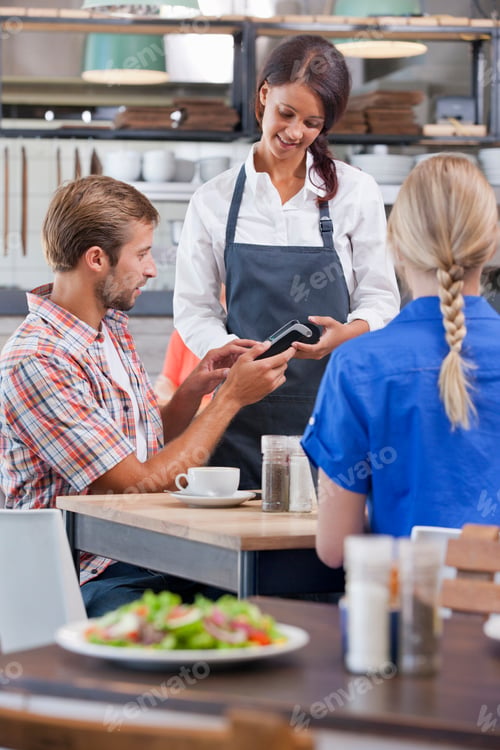 Preview: Vertical Shot Of A Man Making Payment At The Table Of A Restaurant